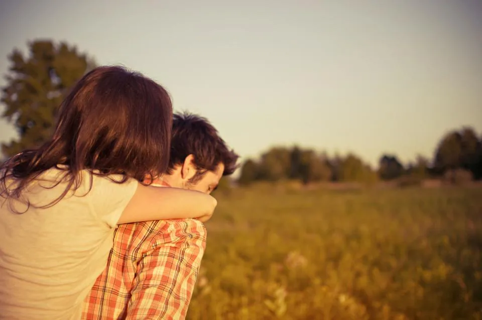 A couple embracing in a sunlit field